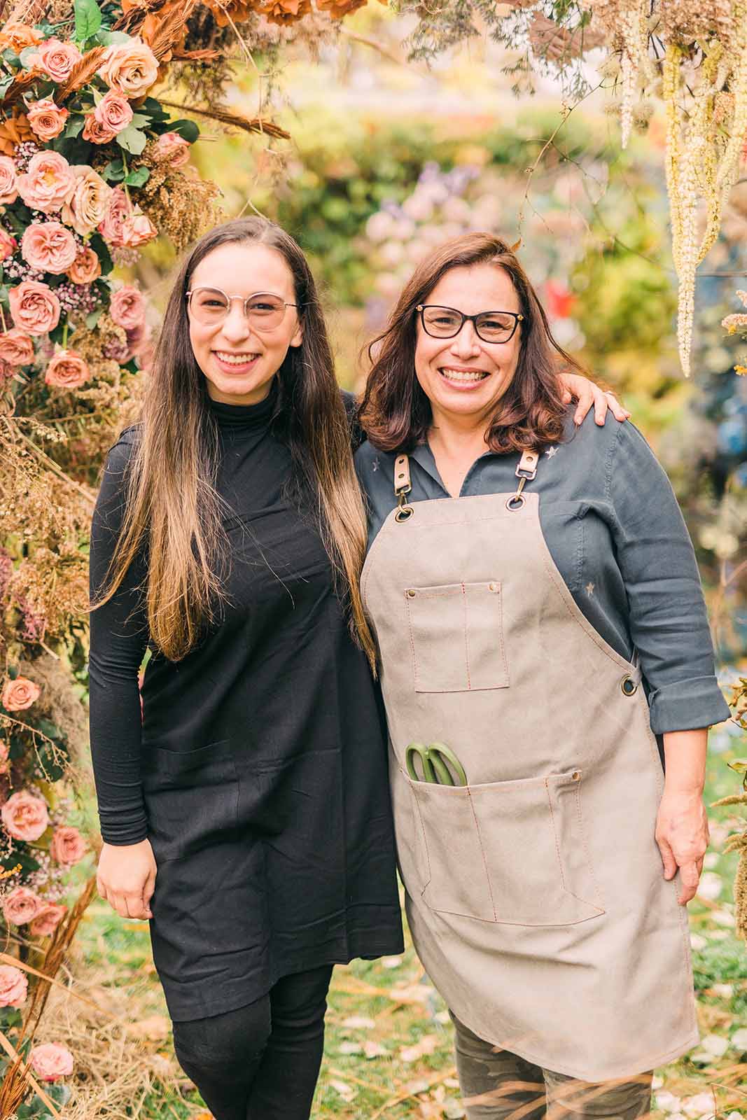 Dos mujeres sonríen entre flores, en una imagen de ANISKA
