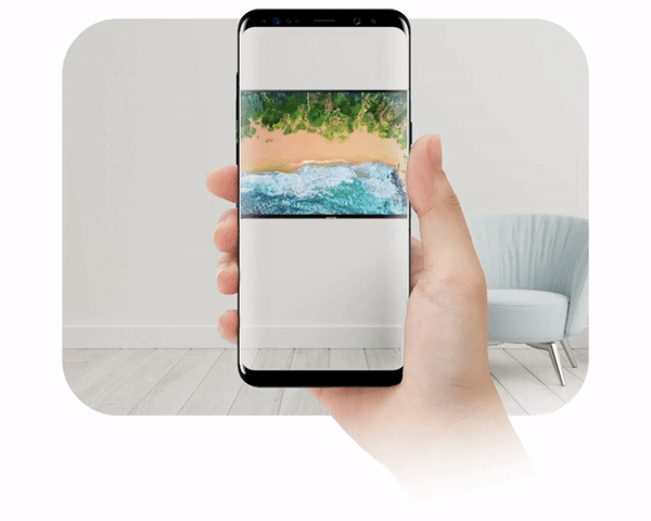 Mano que sostiene un teléfono y coloca un televisor en la pared de una sala con realidad aumentada